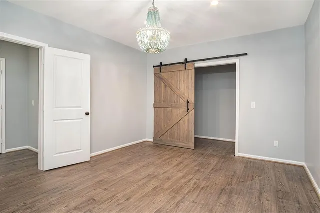 an empty room with wooden floor and entryway