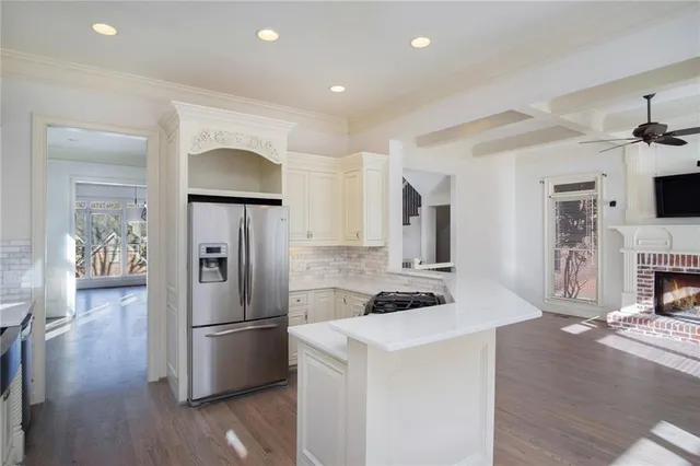 a kitchen with stainless steel appliances a microwave a stove a refrigerator and cabinets