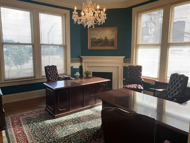 a living room with furniture a chandelier and a fireplace
