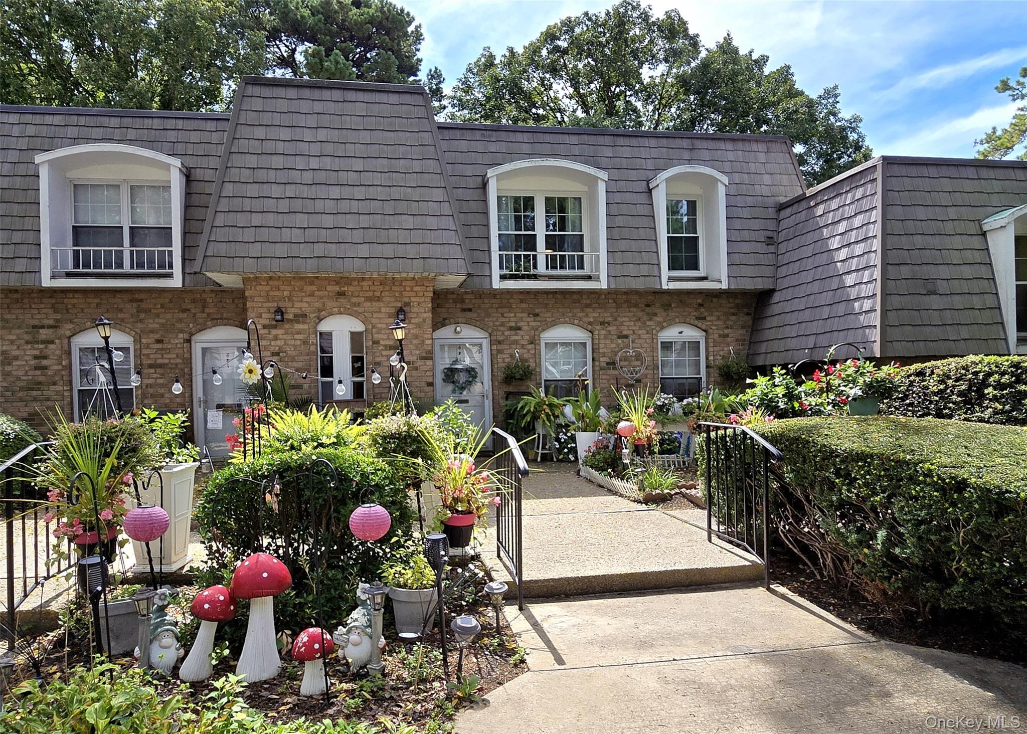 655 Middle Country Road, Unit 4F2 Coram, NY 11727 - Photo 1 of 1 View of property featuring mansard roof, brick siding, and a gate