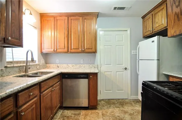 a kitchen with a sink a refrigerator and a stove