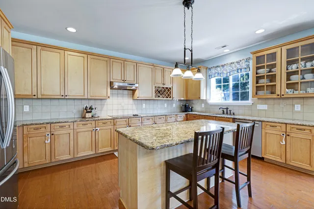 a kitchen with stainless steel appliances granite countertop a sink and dishwasher a stove top oven with wooden floor