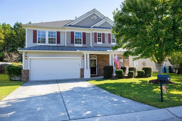 a front view of a house with a yard and potted plants