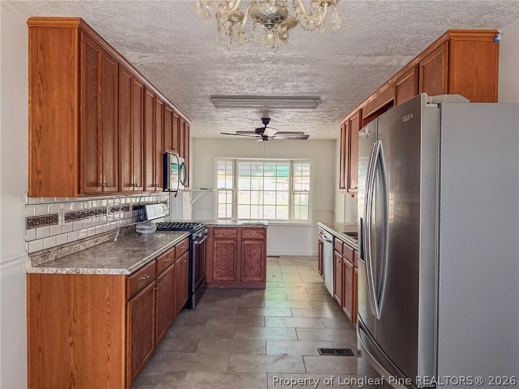 575 Veterans Road St. Pauls, NC 28384 - Photo 6 of 27 a kitchen with stainless steel appliances granite countertop a refrigerator a sink dishwasher and wooden cabinets
