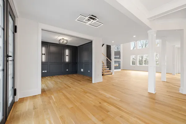 a view of an empty room with window and wooden floor