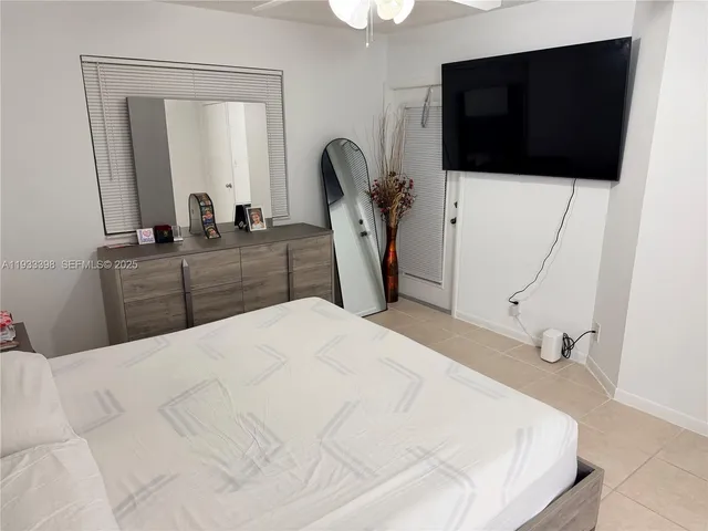 a bedroom with a bed and a flat tv screen on the dresser