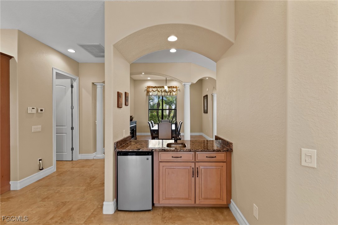 6057 Calusa Rdg Trail Bokeelia, FL 33922 - Photo 10 of 45 a room with kitchen island a sink stainless steel appliances and cabinets