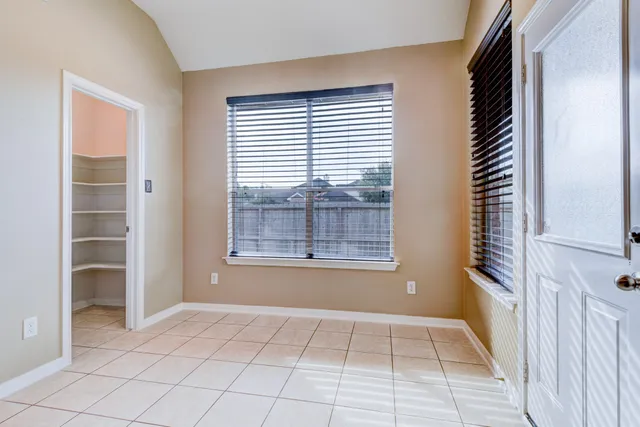 a view of an empty room with a window and a bathroom