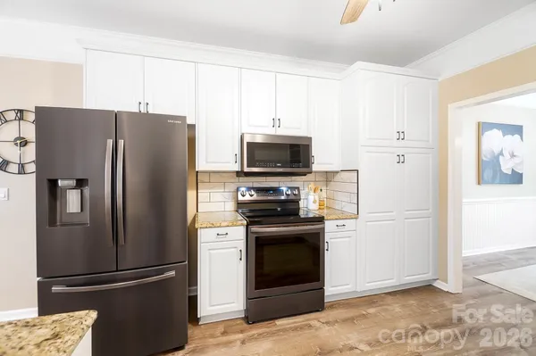 a kitchen with stainless steel appliances granite countertop a refrigerator stove and microwave