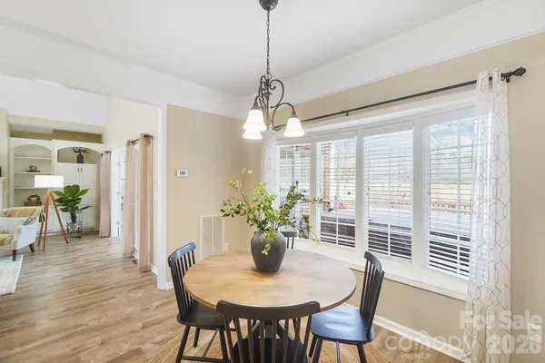 a dining room with furniture potted plants and wooden floor