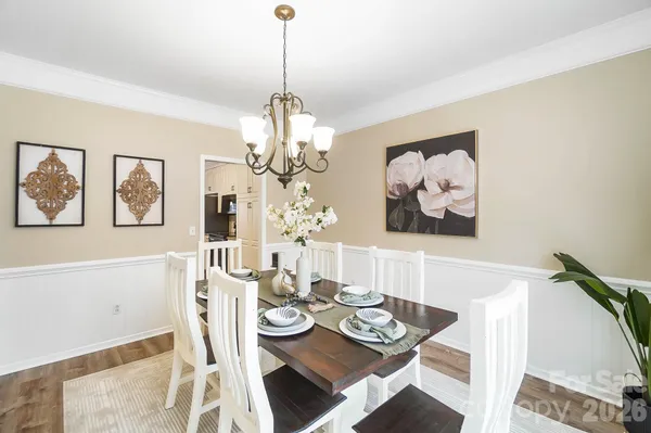 a view of a dining room with furniture a chandelier and wooden floor