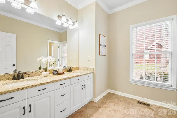 a bath room with a sink double vanity and a mirror