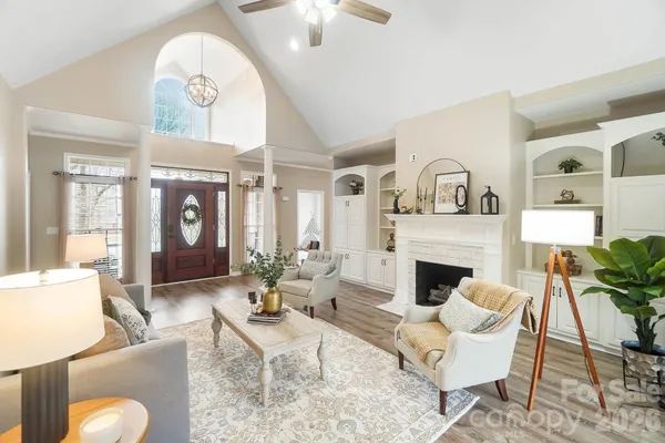 a living room with furniture a fireplace and a chandelier