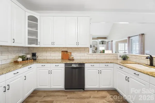 a kitchen with cabinets appliances a sink and a window
