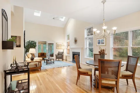 a living room with furniture a fireplace and a chandelier
