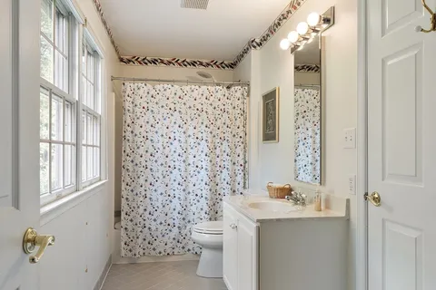 a bathroom with a sink a toilet and shower curtain