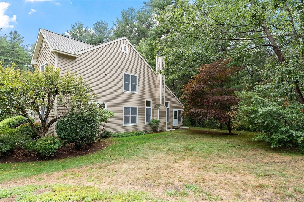 5 Chestnut Lane, Unit 5 Bedford, MA 01730 - Photo 27 of 34 a view of a yard in front of a house with plants and large trees