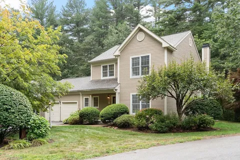 a front view of a house with a yard and potted plants