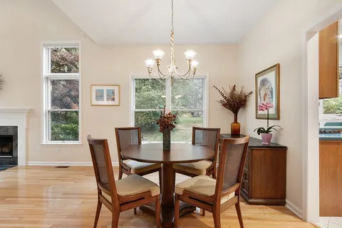 a view of a dining room with furniture a chandelier and wooden floor