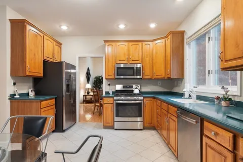a kitchen with stainless steel appliances granite countertop a stove top oven a sink dishwasher and a refrigerator