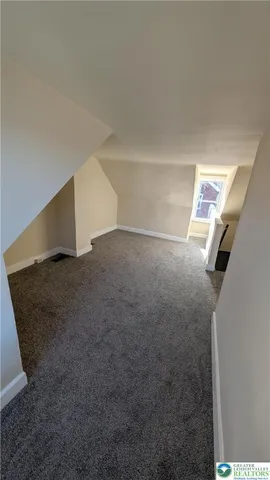 a view of a house with a wooden deck and a forest