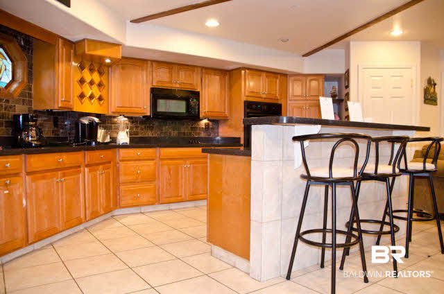 5751 Alabama Street Orange Beach, AL 36561 - Photo 12 of 25 Bar in Kitchen area. Tile floors throughout the Living / Kitchen Area. Also, half bath is located right off the Living area.