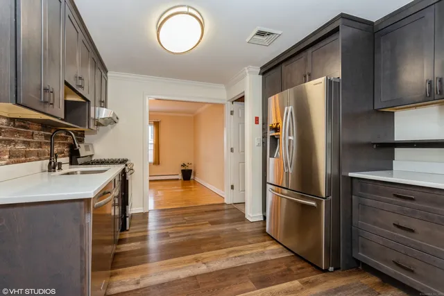 a kitchen with granite countertop a refrigerator stove and sink