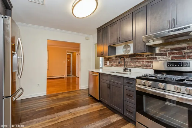 a kitchen with stainless steel appliances granite countertop a stove a refrigerator and a wooden cabinets