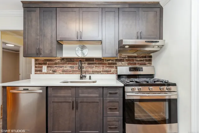 a kitchen with granite countertop a stove sink and cabinets