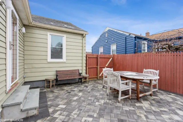 a backyard of a house with a table and chairs