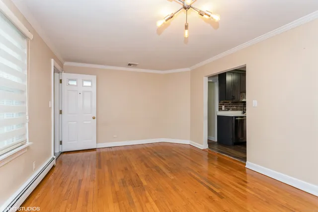 a view of an empty room with wooden floor
