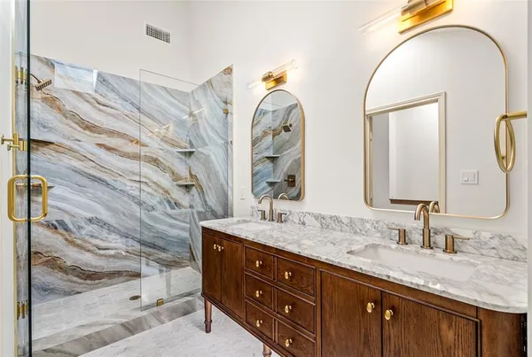 a bathroom with a granite countertop double vanity sink and a mirror