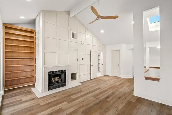 a view of kitchen and empty room with fireplace