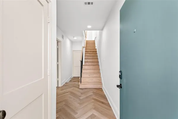 a view of a hallway with stairs and a white floor