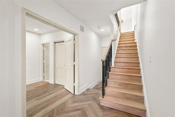 a view of a hallway with staircase and white walls