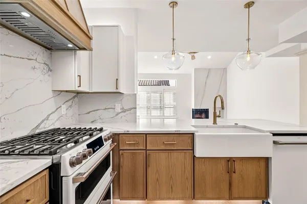 a kitchen with stainless steel appliances granite countertop a sink a stove and a refrigerator