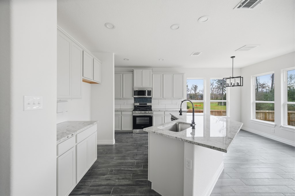 16503 Boston Post Road Cypress, TX 77429 - Photo 15 of 44 a kitchen with stainless steel appliances kitchen island granite countertop a refrigerator and a stove top oven