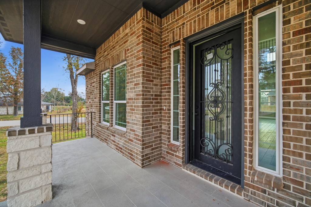 16503 Boston Post Road Cypress, TX 77429 - Photo 2 of 44 A tiled covered front porch leads to a beautifully crafted wood and glass entry door with decorative ironwork.
