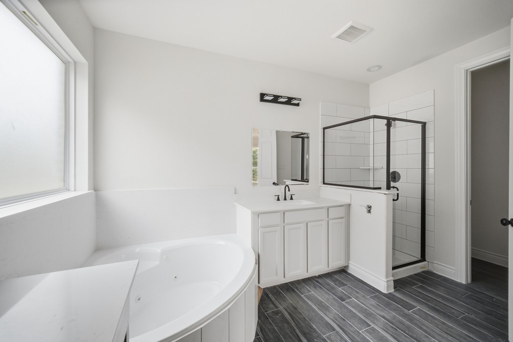 16503 Boston Post Road Cypress, TX 77429 - Photo 25 of 44 Designer touches of tile flooring, black accent light fixtures, and faucets complete the beauty of the primary en suite.