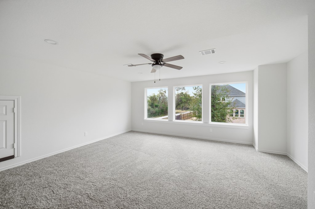 16503 Boston Post Road Cypress, TX 77429 - Photo 29 of 44 an empty room with large windows and a ceiling fan