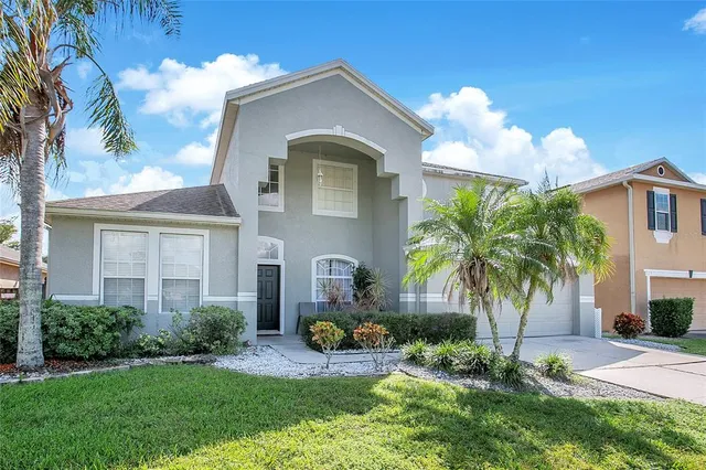 a front view of a house with garden and patio