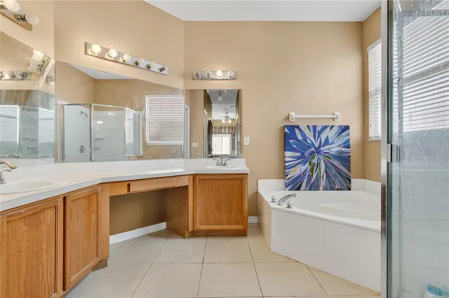a spacious bathroom with a granite countertop sink a bathtub a mirror and vanity