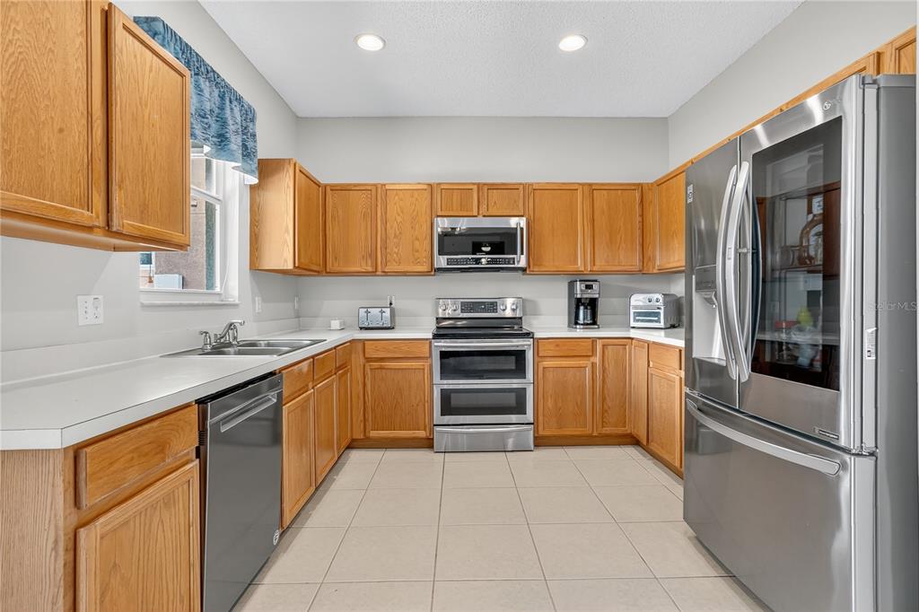 223 Tavestock Loop Winter Springs, FL 32708 - Photo 7 of 27 a kitchen with stainless steel appliances granite countertop a refrigerator and a stove top oven