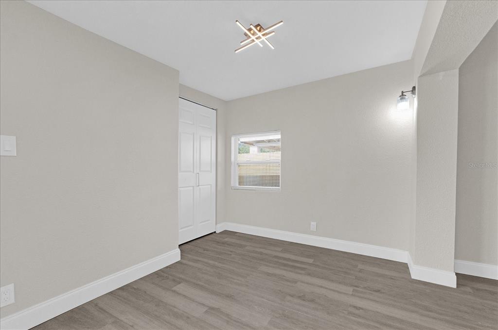 923 Ferndell Road Orlando, FL 32808 - Photo 11 of 42 wooden floor in an empty room with a window