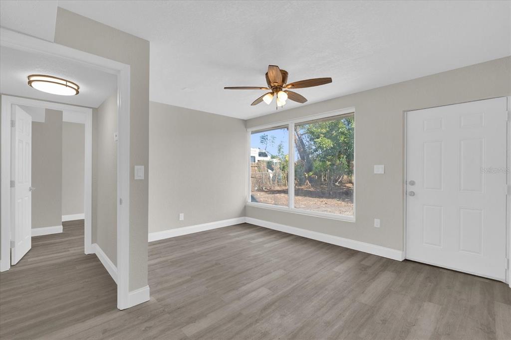 923 Ferndell Road Orlando, FL 32808 - Photo 12 of 42 a view of an empty room with a window and wooden floor