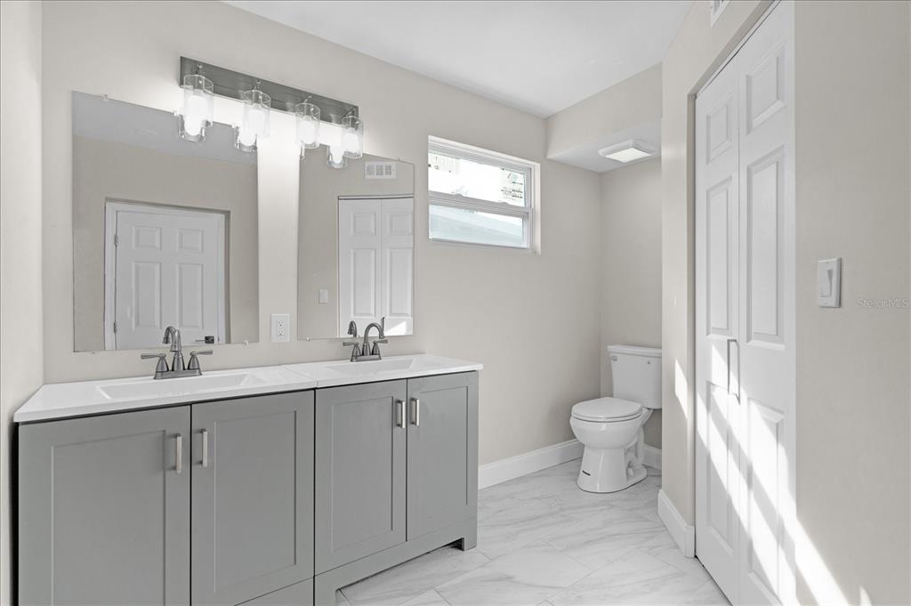 923 Ferndell Road Orlando, FL 32808 - Photo 16 of 42 a bathroom with a toilet sink and mirror