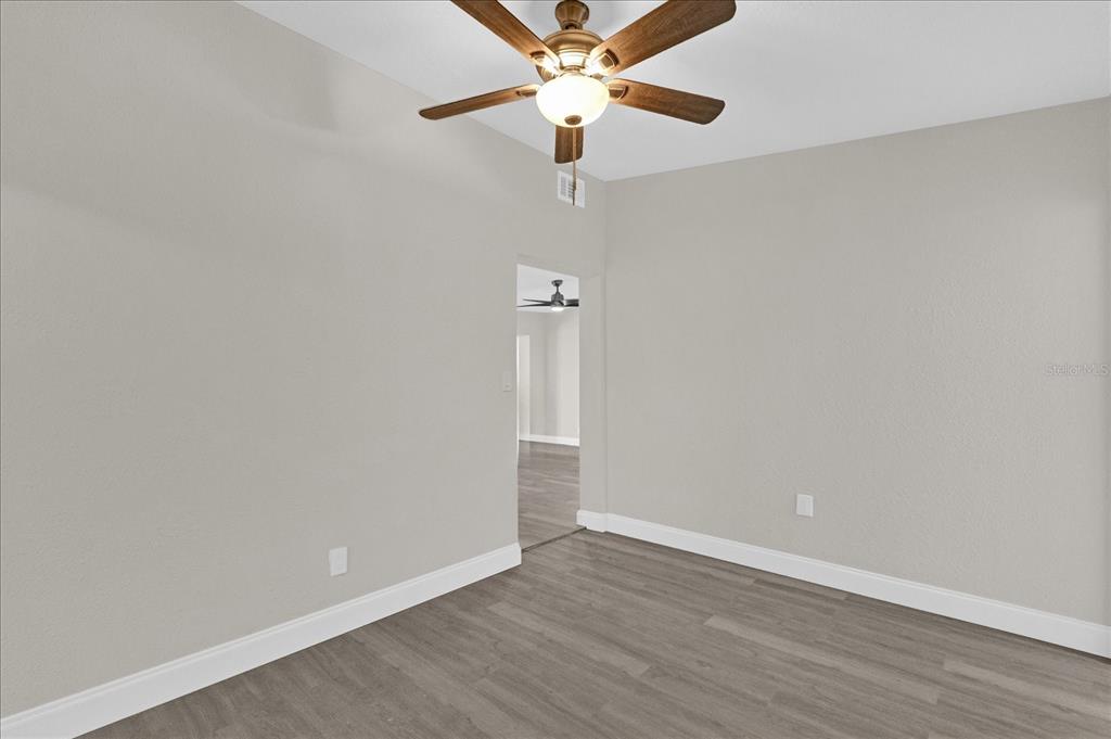 923 Ferndell Road Orlando, FL 32808 - Photo 20 of 42 a view of an empty room with window a ceiling fan and wooden floor