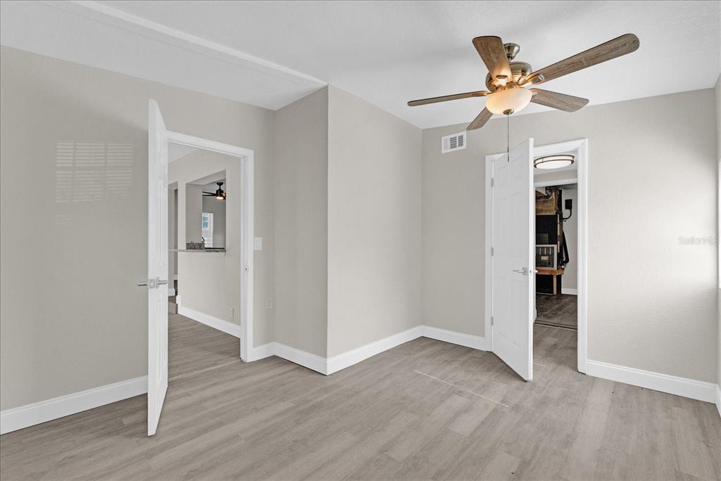 923 Ferndell Road Orlando, FL 32808 - Photo 23 of 42 wooden floor in an empty room with a window