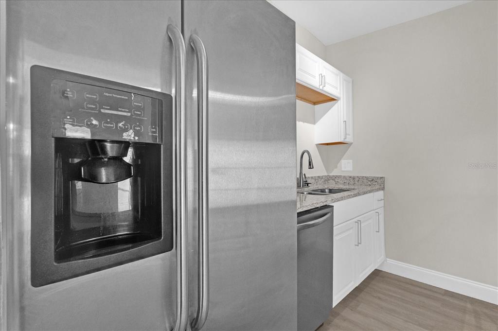 923 Ferndell Road Orlando, FL 32808 - Photo 8 of 42 a kitchen with granite countertop white cabinets and stainless steel appliances