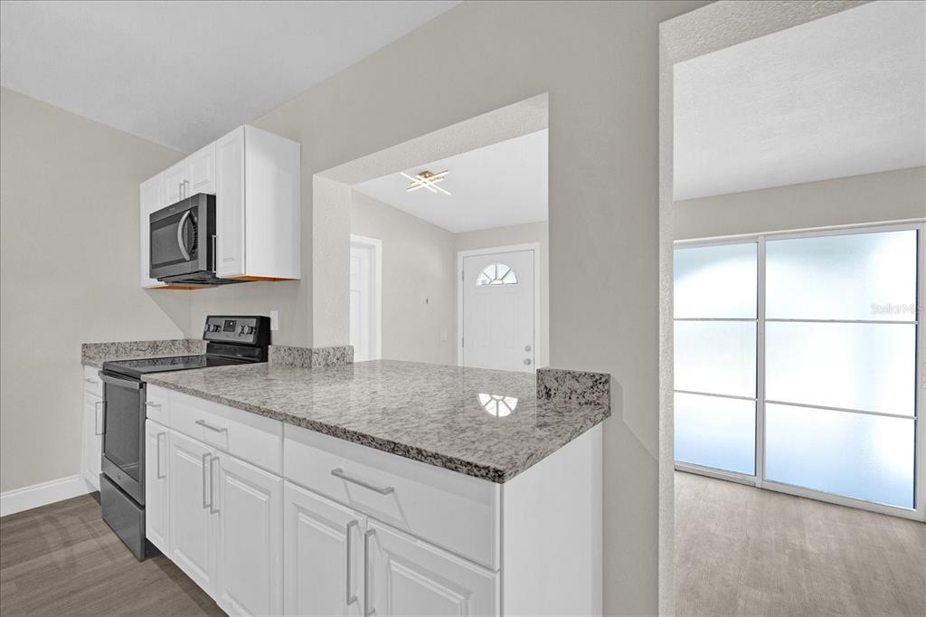 923 Ferndell Road Orlando, FL 32808 - Photo 9 of 42 a kitchen with stainless steel appliances granite countertop a sink and a white cabinets